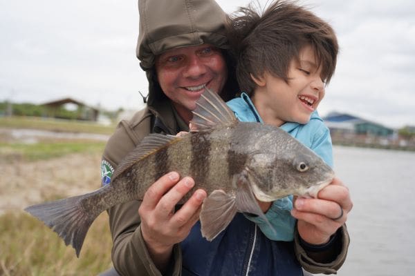 USA Executive Director & CEO Scott Vance helps 5-year-old Luca June, blind since birth, catch his first fish at the USA’s Suncoast Take Kids Fishing Day.