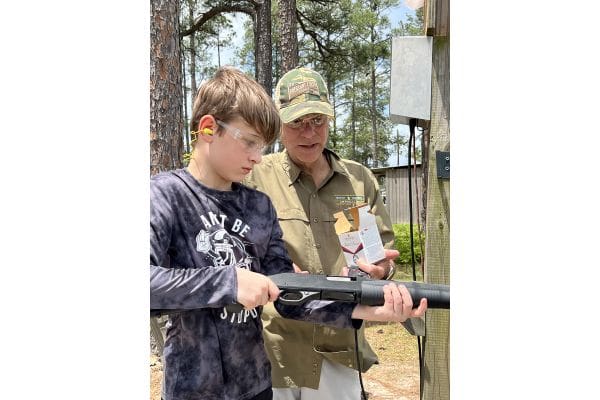 Provost Umphrey Law Firm Managing Partner Joe Fisher explains how to load a shotgun to a youth shooter.